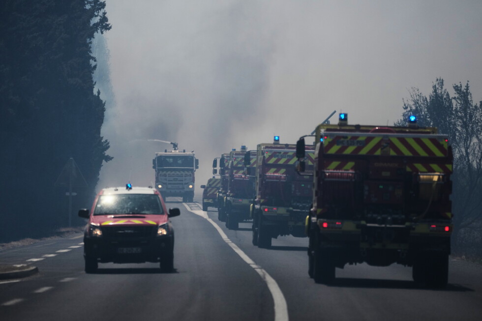 Fire engines drive through heavy smoke from a wildfire in southern France.