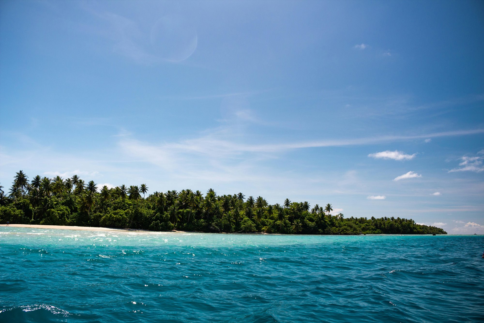 Low-lying tropical island and turquoise ocean in the South-West Pacific.